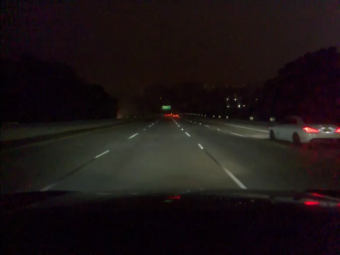 Third nearly identical nighttime highway frame with a white car on the right
